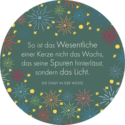 Gezeigt wird eine Innen- oder Zusatzansicht von „Man sieht nur mit dem Herzen gut“. Die runde Ansicht zeigt einen dunkelgrünen Hintergrund, der mit bunten Sternen und Feuerwerksmotiven in Rot, Gelb und Blau verziert ist. Zentral steht in weißer, gut lesbarer Serifen-Schrift ein Zitat, das den Einfluss und die Bedeutung von Licht thematisiert. Darunter ist der Titel „DIE STADT IN DER WÜSTE“ in einer schlichten, klaren Schriftart platziert.