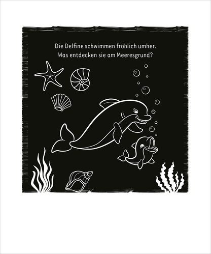 Gezeigt wird eine Innen- oder Zusatzansicht von „Mein cooles leuchtendes Kritzkratz-Buch“. Die Darstellung zeigt zwei fröhlich schwimmende Delfine auf schwarzem Hintergrund. Um sie herum sind verschiedene Meeresobjekte, darunter ein Seestern, eine Muschel und Pflanzen, in Weiß gezeichnet. Oben steht der Text: „Die Delfine schwimmen fröhlich umher. Was entdecken sie am Meeresgrund?“, in einer klaren, gut lesbaren Schriftart, die den spielerischen Charakter des Buches unterstreicht.