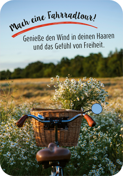 Gezeigt wird eine Innen- oder Zusatzansicht von „99 herrliche Auszeiten für zwischendurch“. Die Szene zeigt einen Fahrradkorb voller Wiesenblumen und einen Teil des Fahrradlenkers im Vordergrund. Der Hintergrund ist ein sonniger, blühender Feld mit grünen Bäumen. In verspielter Schrift steht der einladende Text „Mach eine Fahrradtour!“ in kräftigem Rot, gefolgt von einer motivierenden Botschaft in sanften Grautönen. Die Farben sind warm und einladend, die Gesamtgestaltung wirkt...