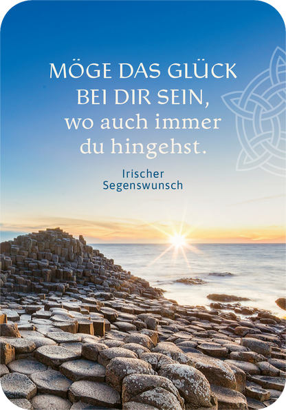 Gezeigt wird eine Innen- oder Zusatzansicht von „Möge das Glück immer bei dir sein!“. Der Hintergrund zeigt eine farbenfrohe Küstenlandschaft mit Sonnenuntergang, wo das Licht sanft über den Horizont strahlt. Im Vordergrund sind natürliche Steinformationen sichtbar. Die Schrift ist in einer eleganten, serifenlosen Typografie gehalten; der Titel ist in kräftigem Blau und hebt sich deutlich vom hellen Hintergrund ab. Darunter befindet sich der Hinweis „Irischer Segenswunsch“ in...