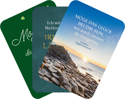 Gezeigt wird eine Innen- oder Zusatzansicht von „Möge das Glück immer bei dir sein!“. Die Karten sind in verschiedenen Farben gehalten: eine grüne Karte mit goldener Schriftfassung, eine hellblaue Karte mit einem irischen Segensspruch und einem Hintergrundbild einer Küstenlandschaft bei Sonnenuntergang. Die Typografie variiert zwischen verspielten und klassischen Schriftarten, die den positiven, einladenden Charakter der Botschaften unterstreichen. Die Karten sind sanft abgerundet und...
