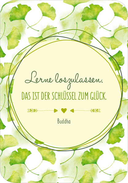 Gezeigt wird eine Innen- oder Zusatzansicht von „Glückskärtchen für Alltagsheldinnen“. Die Karte ist umrahmt von zarten Ginkgo-Blättern in verschiedenen Grüntönen. Im Zentrum befindet sich ein hellbeige kreisförmiger Hintergrund mit der Aufschrift „Lerne loszulassen. DAS IST DER SCHLÜSSEL ZUM GLÜCK.“ in eleganter, geschwungener Schrift. Darunter steht „Buddha“ in einer schlichteren Schriftart. Die harmonischen Farben und die klare Typografie vermitteln eine positive,...