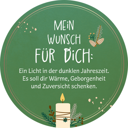 Gezeigt wird eine Innen- oder Zusatzansicht von „Advent in der Dose. 24 liebe Wünsche für dich“. Der Hintergrund ist in einem satten Grün gehalten. Im oberen Bereich steht in großer, handschriftlicher Typografie „MEIN WUNSCH FÜR DICH:“ in Weiß, gefolgt von einem einladenden, fließenden Text, der warmen und positiven Gefühlen Ausdruck verleiht. Unter dem Text ist eine stilisierte Kerze abgebildet, umgeben von zarten, weihnachtlichen Dekorationselementen wie Zweigen und...