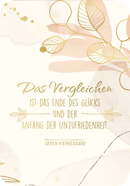 Gezeigt wird eine Innen- oder Zusatzansicht von „Weisheiten für die Seele“. Der Hintergrund ist in sanften, cremigen Tönen gehalten, ergänzt durch zarte, pastellfarbene Pflanzenmotive. In der Mitte steht in eleganter, goldener Schrift der Spruch „Das Vergleichen ist das Ende des Glücks und der Anfang der Unzufriedenheit.“ Unterhalb des Zitats erscheint der Name „Sören Kierkegaard“ in einer schlichten, klaren Schrift. Die gesamte Gestaltung vermittelt eine harmonische und...