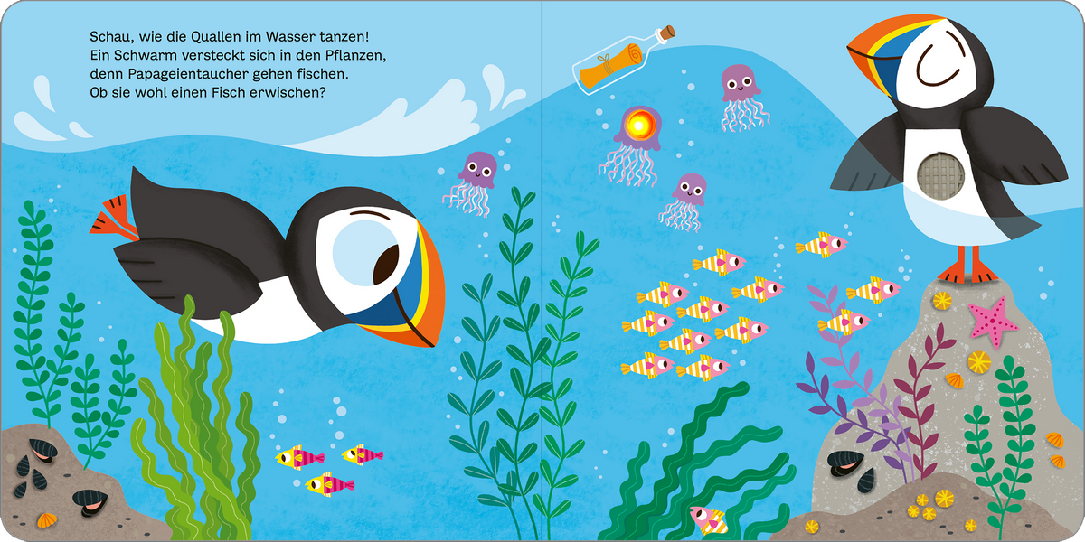 Gezeigt wird eine Innen- oder Zusatzansicht von „Mein blinkendes Soundbuch – Am Meer“. Die Illustration zeigt eine lebendige Unterwasserwelt mit verschiedenen Meeresbewohnern, darunter ein fröhlicher Papageientaucher und bunte Fische. Die Farben sind leuchtend und vielfältig mit Blau- und Grüntönen, die das Wasser und die Pflanzen darstellen. Der Text ist in einer verspielten, gut lesbaren Schriftart gehalten und ermutigt zur Interaktion mit den Abbildungen.