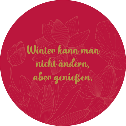Gezeigt wird eine Innen- oder Zusatzansicht von „Adventskalender in der Dose. Glücksmantras“. Der Hintergrund ist in einem kräftigen Rot gehalten, auf dem zarte, goldene Blumenmuster angedeutet sind. In der Mitte steht der Schriftzug „Winter kann man nicht ändern, aber genießen“ in geschwungener, goldener Typografie, die Wärme und Gemütlichkeit ausstrahlt. Die Kombination aus Farben und Formen schafft eine einladende und festliche Atmosphäre.