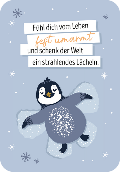Gezeigt wird eine Innen- oder Zusatzansicht von „Ich denk an dich im Advent“. Der Hintergrund ist in sanftem Hellblau gehalten, während ein niedlicher Pinguin mit dunklen und hellen Akzenten auf Schnee dargestellt ist. Über dem Pinguin sind in unterschiedlichen Schriftgrößen die motivierenden Worte „Fühl dich vom Leben fest umarmt und schenk der Welt ein strahlendes Lächeln“ abgedruckt. Die typografische Gestaltung nutzt eine Kombination aus verspielten und klaren Schriftarten.