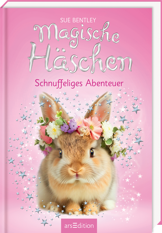 Auf dem Buchcover von „Magische Häschchen – Schnuffeliges Abenteuer“ von Sue Bentley ist ein süßes, flauschiges Kaninchen zu sehen, das mit einem bunten Blumenkranz geschmückt ist. Der Hintergrund ist in einem sanften Rosaton gehalten, durchzogen von glitzernden Sternen, die eine zauberhafte Atmosphäre schaffen. Der Titel ist in verspielter, geschwungener Schrift gestaltet und hebt sich in Weiß ab. Darunter steht die Unterzeile in harmonievollem Schriftbild. Ganz unten mittig steht...