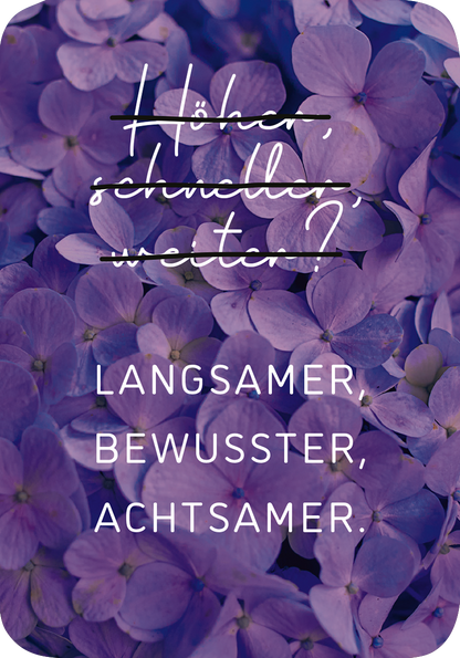 Gezeigt wird eine Innen- oder Zusatzansicht von „Mini-Coach. Willkommen, Achtsamkeit!“. Die Darstellung zeigt eine harmonische Kombination aus lila Blüten, die den Hintergrund prägen. In elegantem, handschriftlichem Stil ist die Frage „Höher, schneller, weiter?“ zu sehen, die durch einen durchgezogenen Strich betont wird. Darunter folgen in klarer, serifenloser Typografie die Worte „Langsamer, bewusster, achtsamer.“ in Weiß, die den zentralen Gedanken des Werkes unterstreichen.