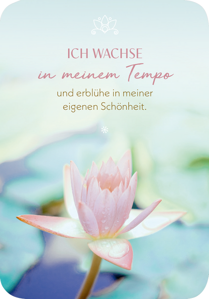 Gezeigt wird eine Innen- oder Zusatzansicht von „Meditations-Mantras“. Der Hintergrund ist in sanften Pastelltönen gehalten, was eine ruhige Stimmung erzeugt. Im Vordergrund steht eine zarte Seerose in rosafarbenen Tönen. Der Text „ICH WACHSÉ in meinem Tempo“ ist in einer eleganten, verschnörkelten Schriftart in einem dunkleren Rosaton platziert. Darunter folgt der Satz „und erblühe in meiner eigenen Schönheit“ in einer schlichteren Schrift, was den harmonischen Gesamteindruck...