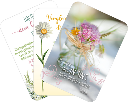 Gezeigt wird eine Innen- oder Zusatzansicht von „Sonne im Herzen“. Die Abbildung umfasst drei Karten mit unterschiedlichen Designs. Die obere Karte zeigt eine Daisy auf hellem Hintergrund mit geschwungener, grüner Schrift. Die mittlere Karte hat eine gebogene, goldene Schrift und veranschaulicht eine hübsche Blume. Die unterste Karte präsentiert eine Fotografie von bunten Blumen in einer Glasvase, umgeben von einem filigranen, verschnörkelten Rahmen und einem Zitat von Buddha in klarer,...