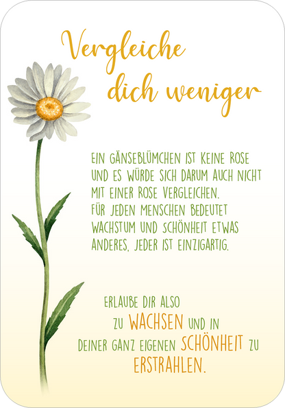 Gezeigt wird eine Innen- oder Zusatzansicht von „Sonne im Herzen“. Das Design zeigt ein zartes Gänseblümchen auf der linken Seite, umrahmt von grünen Blättern. Der Hintergrund ist sanft in einem hellen Pastellton gehalten. Die Schrift ist lebhaft und verspielt, mit der Überschrift „Vergleiche dich weniger“ in goldener Farbe und darunter eine grünen, gut lesbare Schrift für den Text. Die Gestaltung vermittelt eine freundliche und ermutigende Atmosphäre.