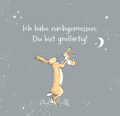 Gezeigt wird eine Innen- oder Zusatzansicht von „Weißt du eigentlich, wie lieb ich dich hab? 99 Gründe, warum ich dich so lieb habe“. Der Hintergrund ist hellgrau, auf dem zwei Illustrationen von Hasen zu sehen sind. Der größere Hase hält einen kleineren Hase in die Höhe. Darüber steht der Text „Ich habe nachgemessen: Du bist großartig!“ in weißer, verspielter Schrift. Kleine Sterne und eine Mondsichel rahmen die Szene ein und verleihen ihr eine verträumte Atmosphäre.