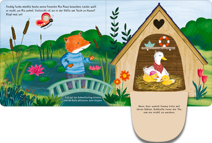 Gezeigt wird eine Innen- oder Zusatzansicht von „Klopf, klopf! Wohnt hier die kleine Maus?“. Die Illustration zeigt einen bunten, fröhlichen Teich mit Wasserlilien und üppigen Pflanzen. Im Vordergrund steht Freddy Fuchs in einem blauen Outfit, der neugierig zur Hütte schaut. Diese ist hellbraun mit einem herzförmigen Fenster und beherbergt eine Ente mit ihren Küken. Die sanften Farben und klare Typografie fördern ein einladendes, kindgerechtes Ambiente.