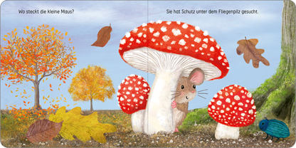 Gezeigt wird eine Innen- oder Zusatzansicht von „Kuckuck, kleines Eichhörnchen!“. Die Illustration zeigt eine niedliche Maus, die sich unter einem großen, roten Fliegenpilz mit weißen Punkten versteckt. Im Hintergrund sind bunte Herbstblätter in Gelb, Orange und Braun zu sehen. Links steht ein gelbblättriger Baum, während rechts ein kleiner Käfer in blauer Farbe dargestellt ist. Die Schrift ist in klar lesbarer, kindgerechter Typografie gehalten, die die Handlung des Bildes...