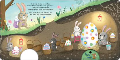 Gezeigt wird eine Innen- oder Zusatzansicht von „Mein liebstes Pustebuch – Frohe Ostern!“. Die farbenfrohe Illustration zeigt eine unterirdische Szenerie mit zwei Hasen, die bunten Ostereiern in Körben umgeben. Eine große, weiß-gelbe Ostereier-Dekoration mit farbigen Punkten steht im Mittelpunkt. Sanfte Pastellfarben dominieren das Bild, ergänzt durch zarte Blumen und eine rot leuchtende Laterne. Der Text ist in einer verspielten Schriftart gehalten und vermittelt eine fröhliche...