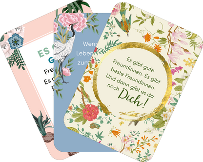Gezeigt wird eine Innen- oder Zusatzansicht von „Weil du eine wundervolle Frau bist!“. Die Ansicht zeigt drei Karten mit unterschiedlichen Designs und Farben. Die linke Karte ist hellrosa mit floralem Muster, während die mittlere Karte in sanftem Blau gehalten ist und eine stilisierte Darstellung eines Schwans zeigt. Die rechte Karte hebt sich durch ein helles, blumiges Muster mit einem goldenen Kranz ab, der den Text „Es gibt gute Freundinnen. Es gibt beste Freundinnen. Und dann gibt es...