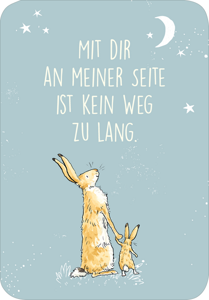Gezeigt wird eine Innen- oder Zusatzansicht von „Weißt du eigentlich, wie lieb ich dich hab? Ich hab dich so lieb!“. Der Hintergrund ist zartblau, geschmückt mit weißen Sternen und einem Mond. In der Mitte steht der Schriftzug „MIT DIR AN MEINER SEITE IST KEIN WEG ZU LANG“ in großer, sanfter Typografie. Zwei niedliche Hasenfiguren sind abgebildet, einer davon etwas größer und der andere kleiner, die gemeinsam in den Himmel blicken.