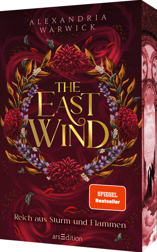 Das Cover ist dunkelrot und zeigt zentral einen opulenten Kranz aus roten und lila Blüten sowie goldenen Blättern. Mittig steht der Titel „THE EAST WIND“ in goldenen Buchstaben, darüber der Name der Autorin Alexandria Warwick. Der Untertitel „Reich aus Sturm und Flammen“ steht am unteren Rand in kleinerer Schrift. Unten rechts befindet sich ein orangefarbener Button mit dem Text „SPIEGEL Bestseller“. Ganz unten mittig steht der Logoschriftzug von arsEdition.