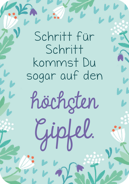 Gezeigt wird eine Innenansicht von „Du bist genau richtig! – 50 Karten für dich“. Die Karte hat einen hellblauen Hintergrund und ist mit zarten, grünen Pflanzenmotiven sowie kleinen, bunten Blumen geschmückt. Der Text in einer Kombination aus handschriftlicher und gerader Schriftart lautet: „Schritt für Schritt kommst Du sogar auf den höchsten Gipfel“.