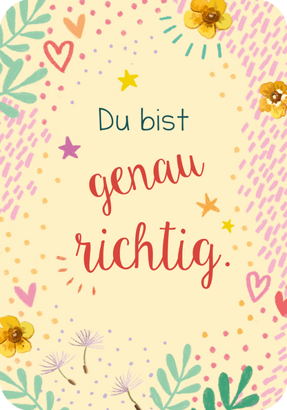 Gezeigt wird eine Innenansicht von „Du bist genau richtig! – 50 Karten für dich“. Der Hintergrund ist sanft gelb mit bunten Elementen wie Herzen, Sternen und Blumen in Pastelltönen. In der Mitte steht „Du bist“ in Blau, gefolgt von „genau richtig.“ in einer roten, geschwungenen Schrift.