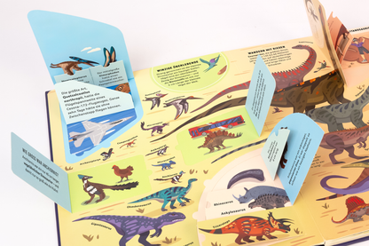 Gezeigt wird eine Innenansicht von „Dinosaurier“. Die Seite präsentiert eine lebendige, farbenfrohe Darstellung verschiedener Dinosaurierarten auf einem hellen Hintergrund. Klappkarten in sanften Blau- und Grüntönen enthalten kurze informative Texte. Die Typografie ist klar und gut lesbar, mit variierenden Schriftgrößen, die wichtige Informationen hervorheben. Illustrationen zeigen Dinosaurier in unterschiedlichen Posen, um das Thema anschaulich zu vermitteln.