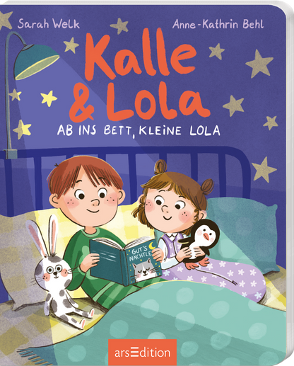 Das Buchcover zeigt zwei Kinder, Kalle und Lola, die in einem gemütlichen Bett sitzen. Kalle, mit kurzen braunen Haaren und einem fröhlichen Gesichtsausdruck, hält ein Buch mit dem Titel „Gut&#039;s Nachte“. Lola, mit langen, lockigen Haaren und einem Kuscheltier in der Hand, strahlt ebenfalls Freude aus. Im Hintergrund sind eine Lampe und bunte Sterne an der Wand zu sehen. Der Titel „Kalle &amp; Lola“ ist in großen, orangefarbenen Buchstaben gehalten. Oben rechts ist der Hinweis...