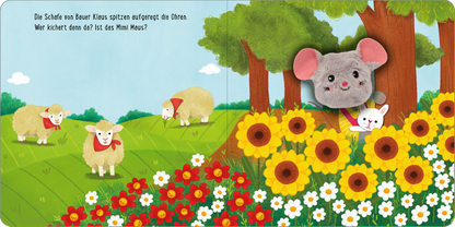 Gezeigt wird eine Innen- oder Zusatzansicht von „Meine sprechende Fingerpuppe: Was sagt die Maus?“. Im Illustrationsstil sind grüne Wiesen mit bunten Sonnenblumen und weißen Gänseblümchen dargestellt. Auf der linken Seite stehen zwei gefütterte Schafe mit roten Halstüchern. Auf der rechten Seite versteckt sich eine grau-rosa Maus zwischen Bäumen. Der Hintergrund ist hellblau mit sanften Wolken. Die Schrift in der oberen linken Ecke ist klar und gut lesbar, mit einem freundlichen,...