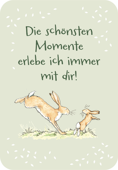 Gezeigt wird eine Innen- oder Zusatzansicht von „Weißt du eigentlich, dass du mein größter Schatz bist?“. Auf einem sanften, hellgrünen Hintergrund sind zwei niedliche, illustrierte Hasen zu sehen, die sich fröhlich an einem Grashalm begegnen. Darüber steht in großen, freundlichen Buchstaben der Satz „Die schönsten Momente erlebe ich immer mit dir!“, welcher in einer verspielten Schriftart gehalten ist. Die Gesamtgestaltung vermittelt eine warme und liebevolle Stimmung.