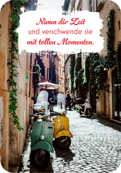 Gezeigt wird eine Innen- oder Zusatzansicht von „Dein Urlaubsorakel“. Die Szene zeigt eine enge, malerische Gasse mit gepflastertem Boden, gesäumt von historischen Gebäuden und üppigem Grün. Zwei auffällige scooters in sanften Farben, mintgrün und gelb, stehen am Straßenrand. Darüber schwebt eine Einladung in roter Schrift auf weißem Hintergrund: „Nimm dir Zeit und verschwende sie mit tollen Momenten.“ Die Typografie ist verspielt und einladend, was die entspannte...