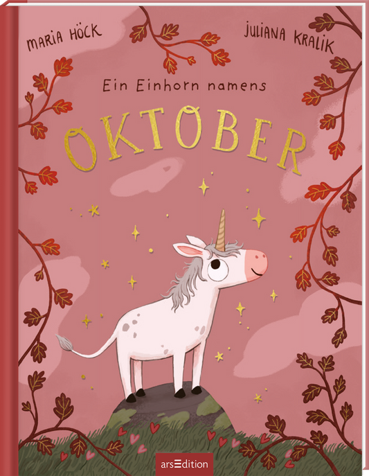 Auf rosarotem Grund steht ein kleines weißes Einhorn mit goldener Hornspitze auf einem grünen Hügel, umgeben von goldenen Sternchen und herbstlichen Zweigen mit roten Blättern. Titel „Oktober“ groß in goldener, handschriftlicher Schrift, darüber klein „Ein Einhorn namens“, oben links Autorenname Maria Höck, oben rechts Juliana Kralik. Ganz unten mittig steht der Logoschriftzug von arsEdition.