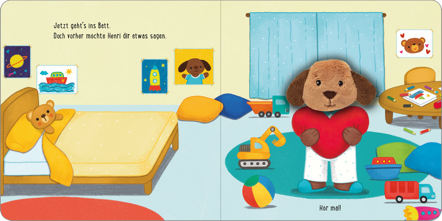 Gezeigt wird eine Innen- oder Zusatzansicht von „Meine sprechende Fingerpuppe: Was sagt der Hund?“. Die Bildseite zeigt ein Kinderzimmer mit bunten Wänden und einem großen Fenster, durch das Licht strömt. Links steht ein Bett mit gelber Bettdecke und einem Teddy. Rechts steht die Fingerpuppe einladend, mit einem roten Herz in den Händen und einem freundlichen Gesicht. Spielsachen liegen verstreut auf dem Boden, darunter Bälle und Bauklötze, die farbenfroh gestaltet sind. Die Schrift...