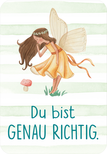 Gezeigt wird eine Innen- oder Zusatzansicht von „Mutmachkarten – Einhorn (Aquarelloptik)“. Die Karte zeigt eine fröhliche, handgezeichnete Fee mit langen, braunen Haaren und durchsichtigen Flügeln, die in einem gelben Kleid mit Gürtel und Schleife steht. Im Hintergrund sind sanfte grüne Streifen zu sehen. Die Aussage „Du bist GENAU RICHTIG.“ ist in einer verspielten, blauen Schriftart mittig platziert, wodurch eine positive und ermutigende Atmosphäre entsteht.