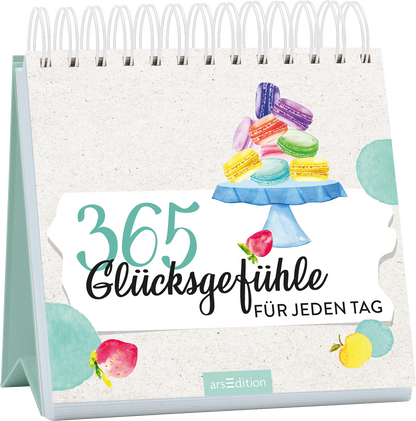 Auf dem Buchcover steht der Titel „365 Glücksgefühle“ in großen, lebendigen Farben, begleitet von der Unterzeile „FÜR JEDEN TAG“ in einer eleganten Schriftart. Ein blauer Kuchenstand präsentiert farbenfrohe Macarons und Früchte, die eine fröhliche und einladende Atmosphäre schaffen. Der Hintergrund ist in sanften, neutralen Tönen gehalten. Ganz unten mittig steht der Logoschriftzug von arsEdition.