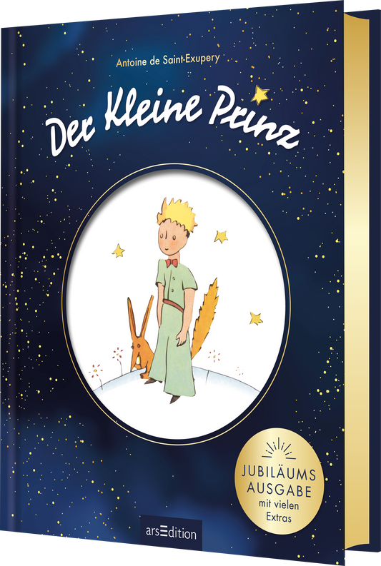 Das Cover zeigt einen nächtlichen Himmel in tiefblauem Farbton mit goldenen Sternen. In der Mitte befindet sich eine kreisrunde Illustration, die den kleinen Prinzen mit gelbem Haar und einem grünen Anzug darstellt, zusammen mit einem Fuchs. Der Titel „Der kleine Prinz“ ist in geschwungener, weißer Schrift über der Illustration platziert. Rechts unten ist ein goldener Button mit dem Text „JUBILÄUMSAUSGABE mit vielen Extras“ zu sehen. Ganz unten mittig steht der Logoschriftzug von...
