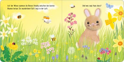 Gezeigt wird eine Innen- oder Zusatzansicht von „Meine sprechende Fingerpuppe: Hops Hase“. Die Illustration zeigt eine blühende Wiese mit bunten Blumen in Gelb, Lila, Rosa und Weiß. In der Mitte sitzt ein niedlicher Hase mit großen Ohren in sanftem Braunton. Um ihn summen fröhliche Bienen. Die Schrift ist klar und kindgerecht, mit einer verspielten Anordnung auf der Seite. Die Gesamtgestaltung vermittelt eine fröhliche, einladende Atmosphäre.