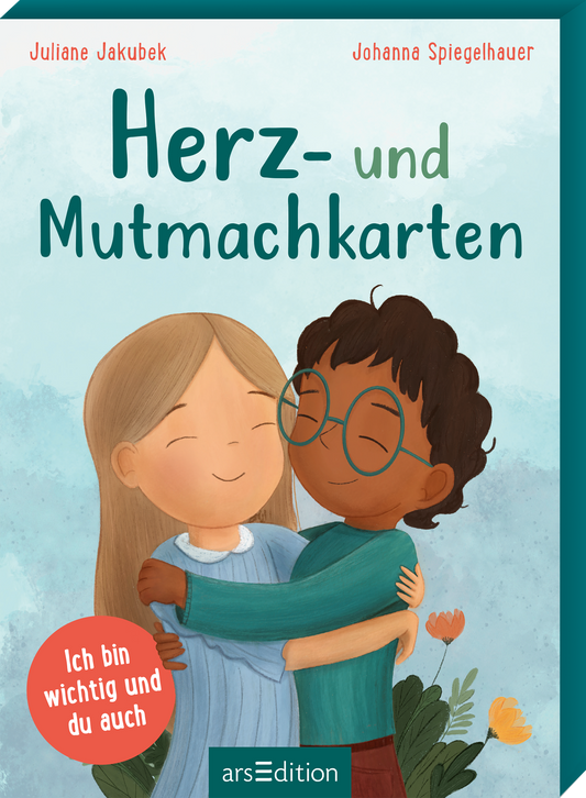 Pastellhelles Cover mit türkisgrünem Rahmen und aquarelligem hellblauem Hintergrund, freundliche warme Atmosphäre. Titel „Herz- und Mutmachkarten“ groß, rund und türkisgrün gesetzt. Oben links „Juliane Jakubek“, oben rechts „Johanna Spiegelhauer“ in kleiner roter Schrift. Illustration zeigt zwei Kinder beim Umarmen, eines blond, eines mit dunklerer Haut und Brille, Blumen unten rechts. Roter Kreis mit weißer Aufschrift „Ich bin wichtig und du auch“. Ganz unten mittig...