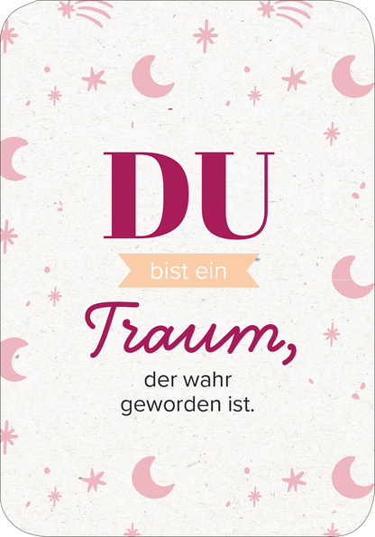 Gezeigt wird eine Innen- oder Zusatzansicht von „50 ungewöhnliche Liebeserklärungen“. Der Hintergrund ist hell mit zarten, bunten Sternen und Mondsymbolen in Rosa. In der Mitte steht der große, dunkelrote Schriftzug „DU“, gefolgt von dem leicht versetzten, hellen Text „bist ein“ und dem schwungvollen Wort „Traum,“ in kräftigem Pink. Darunter steht in eleganter, roter Schrift: „der wahr geworden ist“. Die harmonische Farb- und Schriftkombination erzeugt eine romantische...