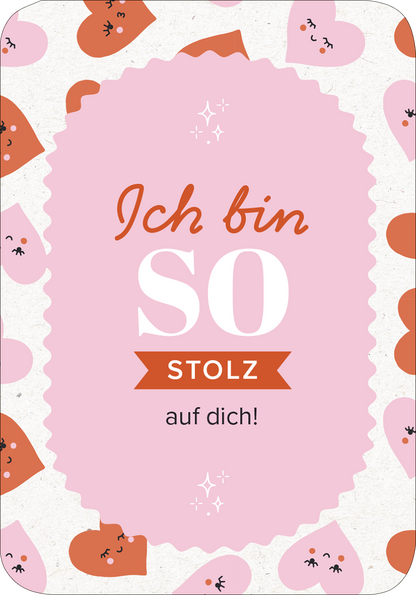 Gezeigt wird eine Innen- oder Zusatzansicht von „50 ungewöhnliche Liebeserklärungen“. Die Gestaltung des Kartenmotivs umfasst einen zarten rosa Hintergrund, umrandet von einer wulstigen, lila Form. In der Mitte ist der Text „Ich bin SO stolz auf dich!“ in einer Kombination aus verspielter Schriftart und klarer Typografie dargestellt. Um den Text herum sind niedliche, lächelnde Herzchen in verschiedenen Farben angeordnet, was dem Gesamtlayout einen fröhlichen und liebevollen...