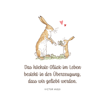 Gezeigt wird eine Innen- oder Zusatzansicht von „Weißt du eigentlich, wie lieb ich dich hab? 365 Liebesbotschaften für dich“. Die Illustration zeigt zwei niedliche Hasen: ein größerer Hase überreicht einem kleineren Hase eine Blume. Über der Szene schweben zwei Herzen in zartem Rosa. Der Hintergrund ist schlicht weiß, während die Schrift in einer warmen, braunen Serifenschrift gestaltet ist. Der Text lautet: „Das höchste Glück im Leben besteht in der Überzeugung, dass wir...