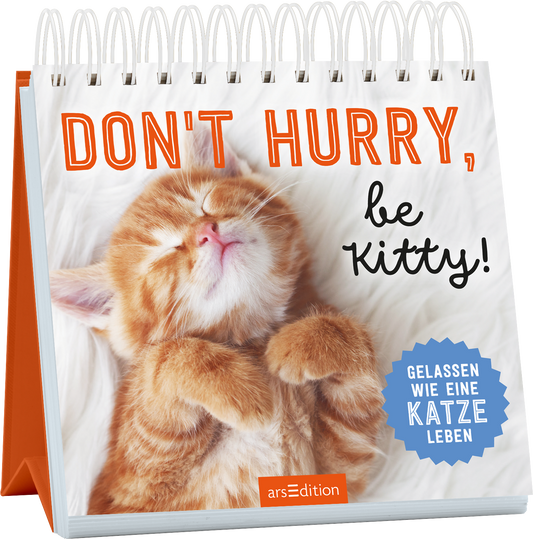 Auf dem Cover ist ein schlafendes, orangefarbenes Kätzchen mit geschlossenen Augen zu sehen, das eine entspannte Pose einnimmt. Der Hintergrund ist hell und weich gestaltet. Der Titel „DON'T HURRY, be KITTY!“ ist in einer großen, orangefarbenen Schrift platziert, während der Untertitel „GELASSEN WIE EINE KATZE LEBEN“ in einer blauen, runden Auszeichnung hervorgehoben wird. Ganz unten mittig steht der Logoschriftzug von arsEdition.