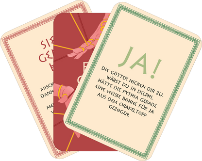 Gezeigt wird eine Innen- oder Zusatzansicht von „Frag die Götter“. Auf der Karte in der Mitte steht „JA!“ in grüner, verspielter Typografie auf hellem Hintergrund. Die anderen Karten zeigen Rottöne mit goldener Akzentuierung und einer eleganten, klassischen Schrift. Alle Karten sind mit einem dekorativen, grünen Rahmen verziert. Die Illustrationen und Farben vermitteln eine mystische Stimmung, die das Orakel-Thema unterstreicht.