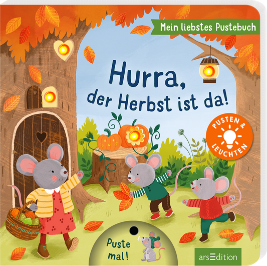 Fröhliches Kinderbuchcover mit warmen Herbstfarben: oranges und goldenes Laub, hellblauer Himmel, grüne Wiese. Drei anthropomorphe Mäuse in bunter Kleidung spielen mit Blättern vor einem hohlen Baum mit Tür und leuchtenden Laternen. Mittig oben der Titel „Hurra, der Herbst ist da!“ in rundlicher, verspielter blauer Typografie, oben rechts das grüne Bändchen „Mein liebstes Pustebuch“ und orangefarbener Button „Pusten und Leuchten“. Ganz unten mittig steht der Logoschriftzug...