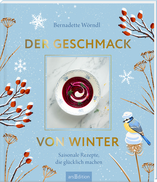 Auf dem Buchcover von „Der Geschmack von Winter“ von Bernadette Wörndl dominieren sanfte Himmelblau- und Weißtöne. In der Mitte befindet sich ein Bild einer Schüssel mit roter Suppe, dekoriert mit Sahne und Gewürzen. Umrahmt wird das Cover von winterlichen Motiven, darunter schneebedeckte Zweige und kleine Vögel. Der Titel und die Unterzeile sind in goldener Schrift gehalten und heben sich eindrucksvoll vom Hintergrund ab. Ganz oben rechts ist ein Button mit dem Text „SPIEGEL...