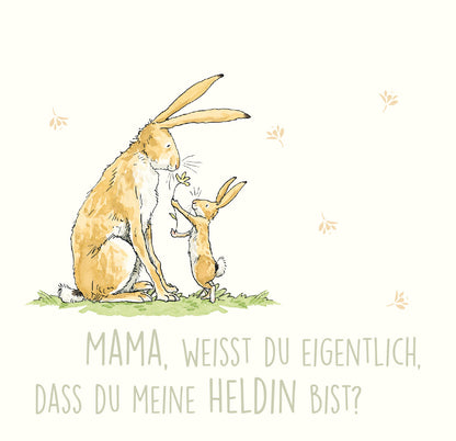 Gezeigt wird eine Innen- oder Zusatzansicht von „Weißt du eigentlich, wie lieb ich dich hab?“. Die Illustration zeigt einen großen Hasen und ein kleineres Kind, die sich liebevoll gegenüberstehen. Der große Hase sitzt aufrecht, während das kleinere Häschen ihm eine Blume anbietet. Der Hintergrund ist in sanften, hellen Farben gehalten, wobei die Schrift „MAMA, WEISST DU EIGENTLICH, DASS DU MEINE HELDIN BIST?“ in freundlicher, runder Typografie in beige erscheint. Kleine, durch die...