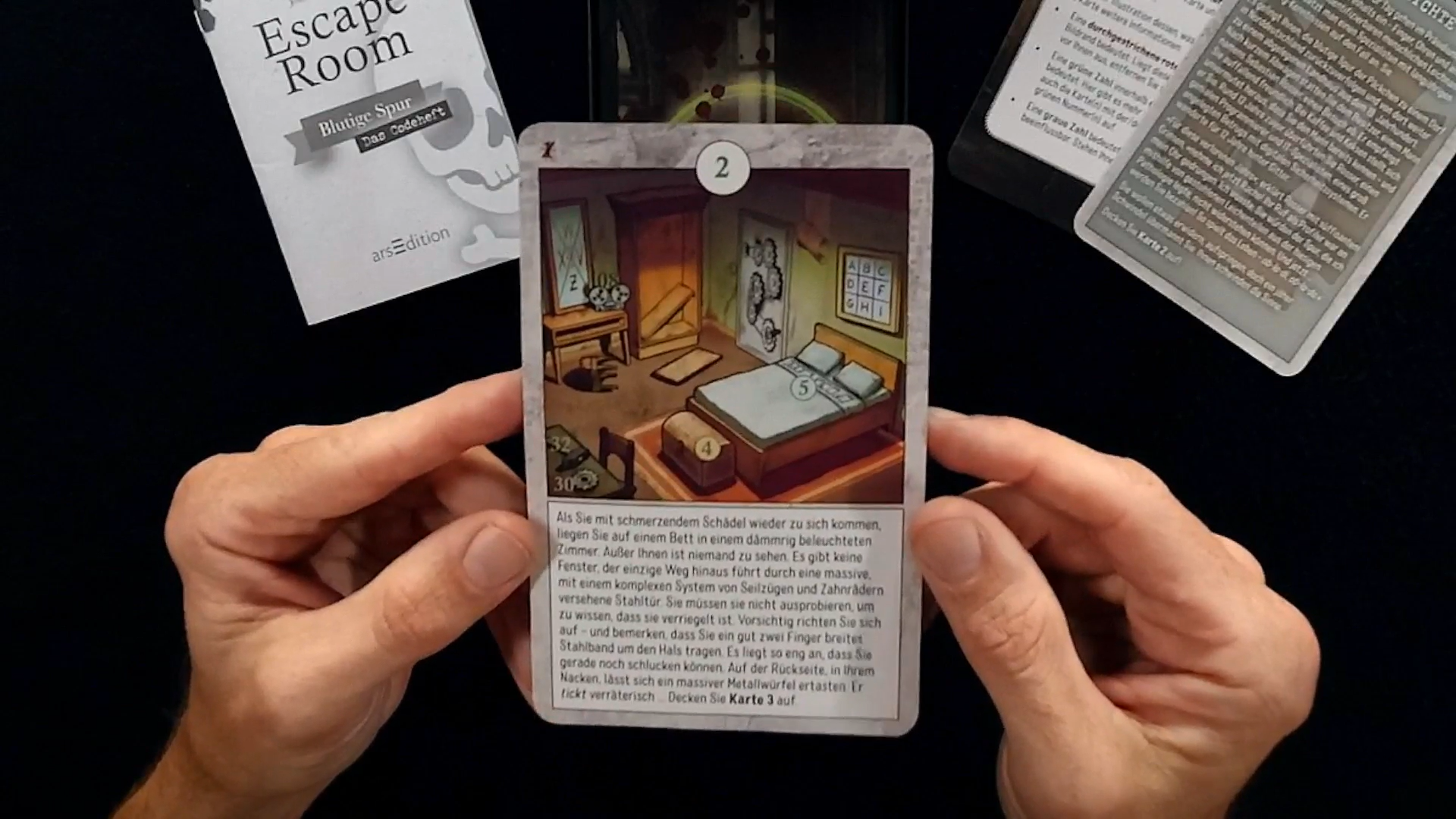 Video laden: Hände halten Kartenspiel und eine Stimme im Hintergrund erklärt das Spiel.