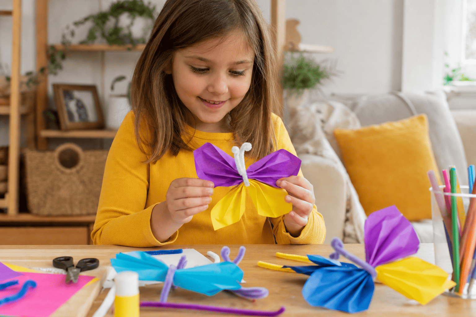 Kind Mädchen im Grundschulalter hat einen selbergebastelten Schmetterling aus Papier in der Hand. Sie trägt ein gelbes Shirt, ihre Haare sind braun. Der Schmetterling ist lila und gelb. Das Bild wurde mit Hilfe von künstlicher Intelligenz erstellt.