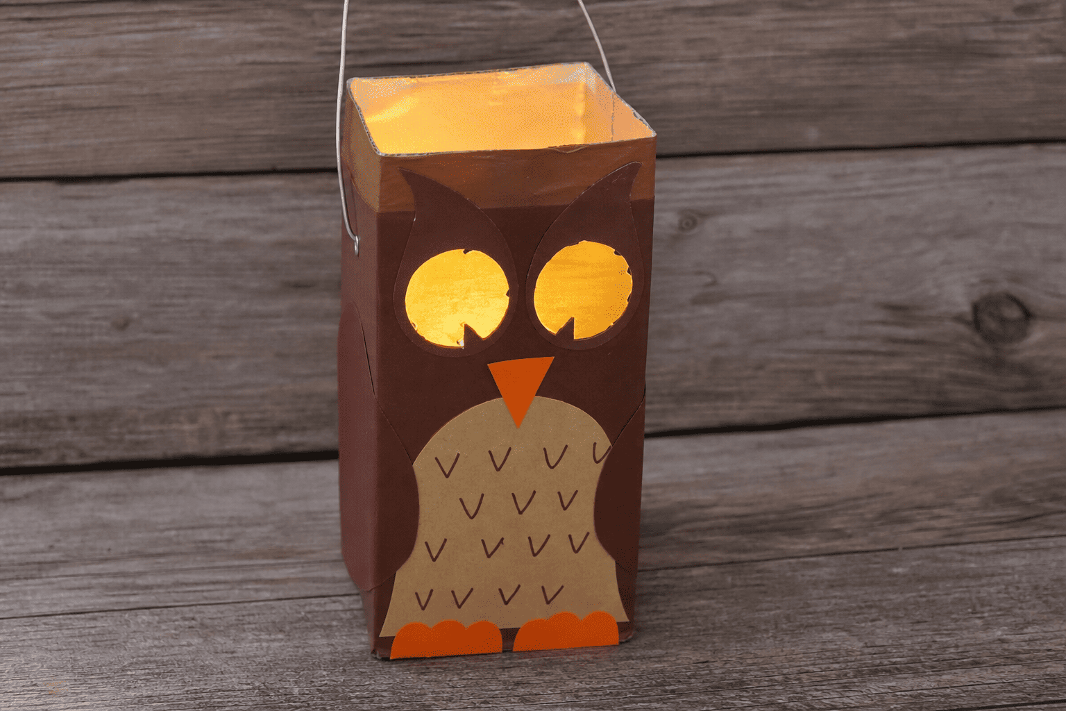 Eine selbstgebastelte Laterne für Kinder aus einem Tetrapak. Die Laterne soll eine Eule darstellen. Mit Hilfe von KI generiert.