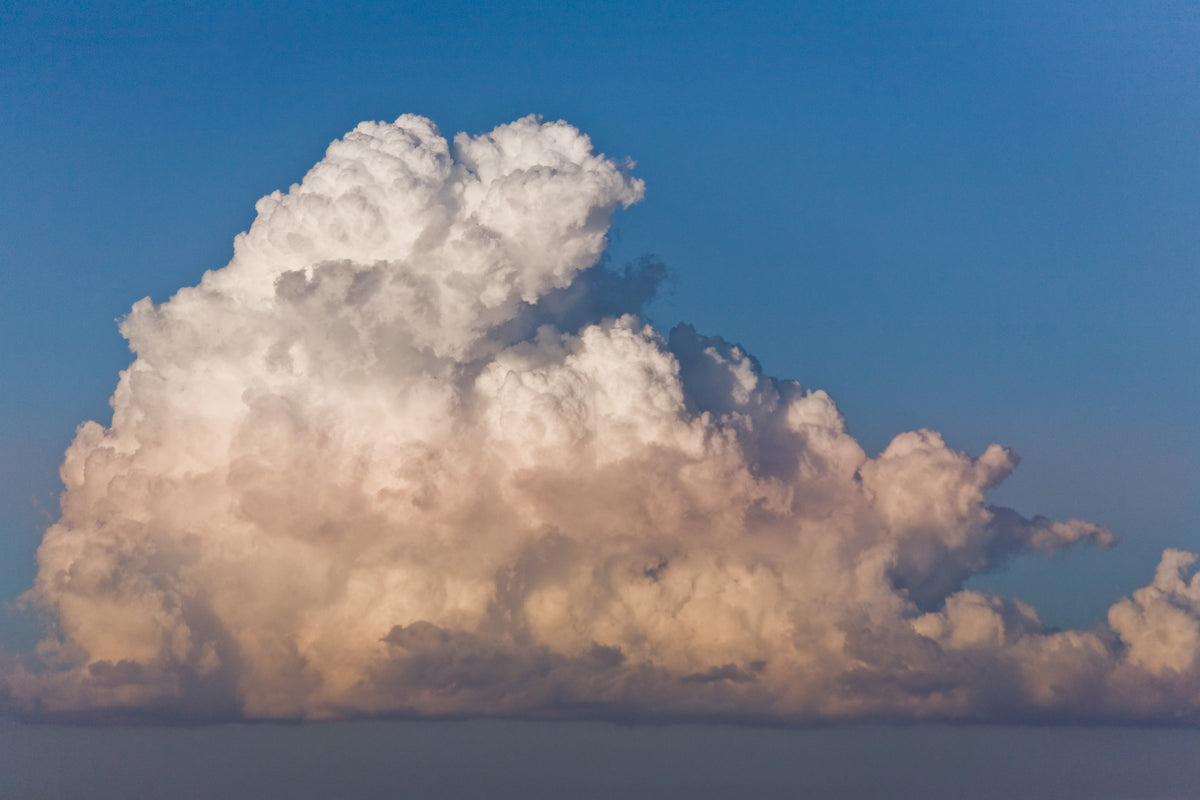 Eine große weiße Wolke vor einem blauen Himmel